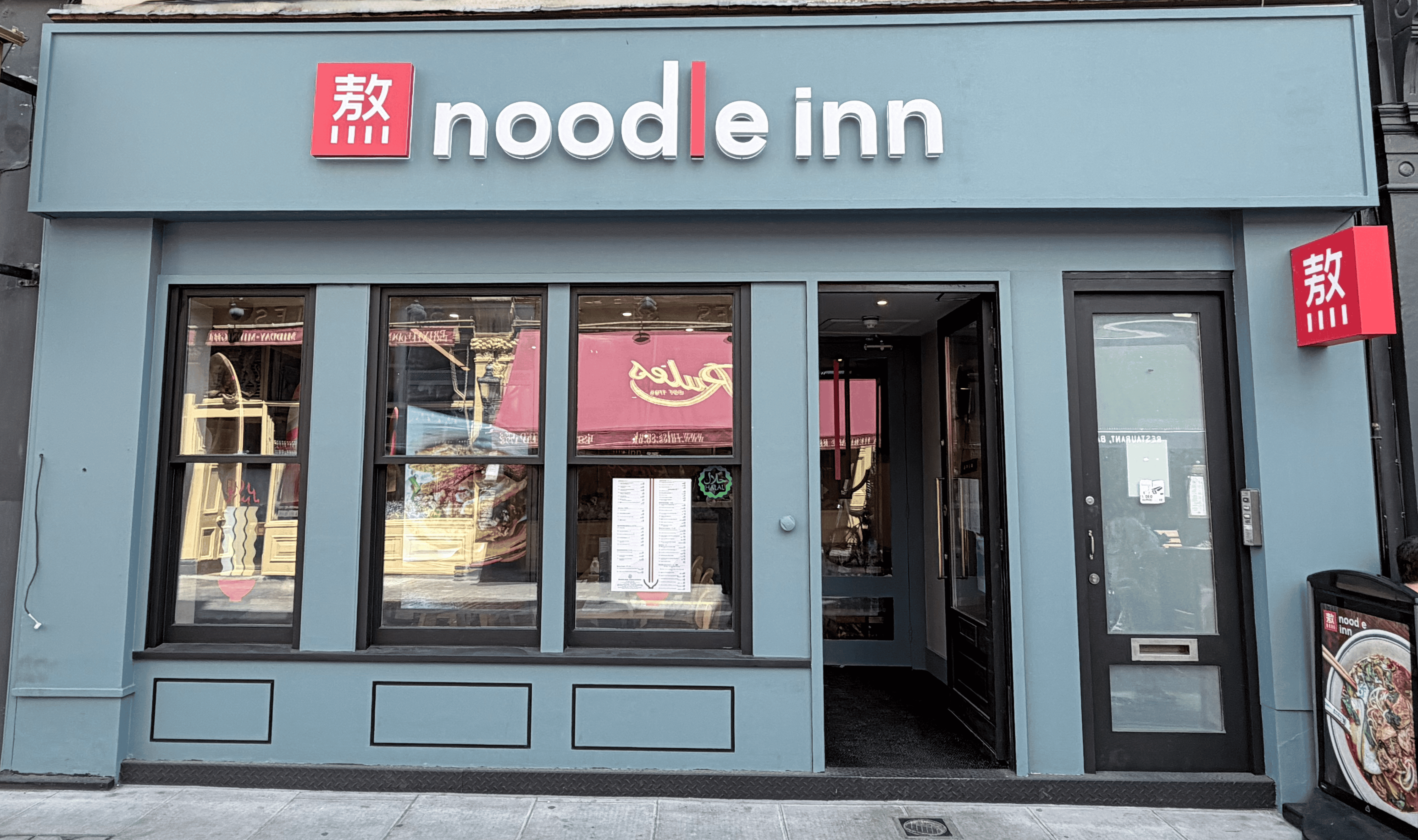 Noodle Inn storefront with signage and large windows.