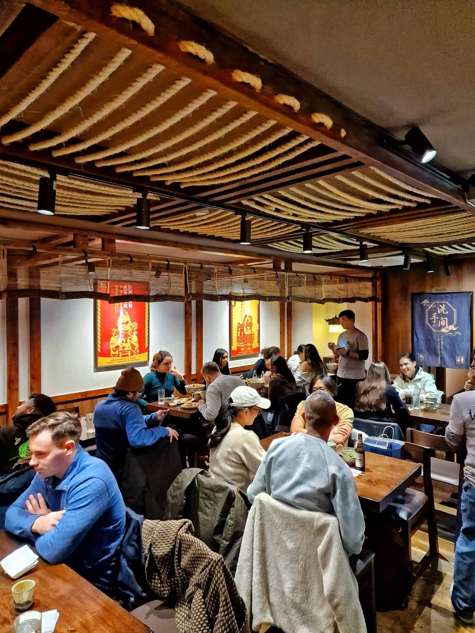 Interior view of Noodle Inn with customers enjoying Asian cuisine.