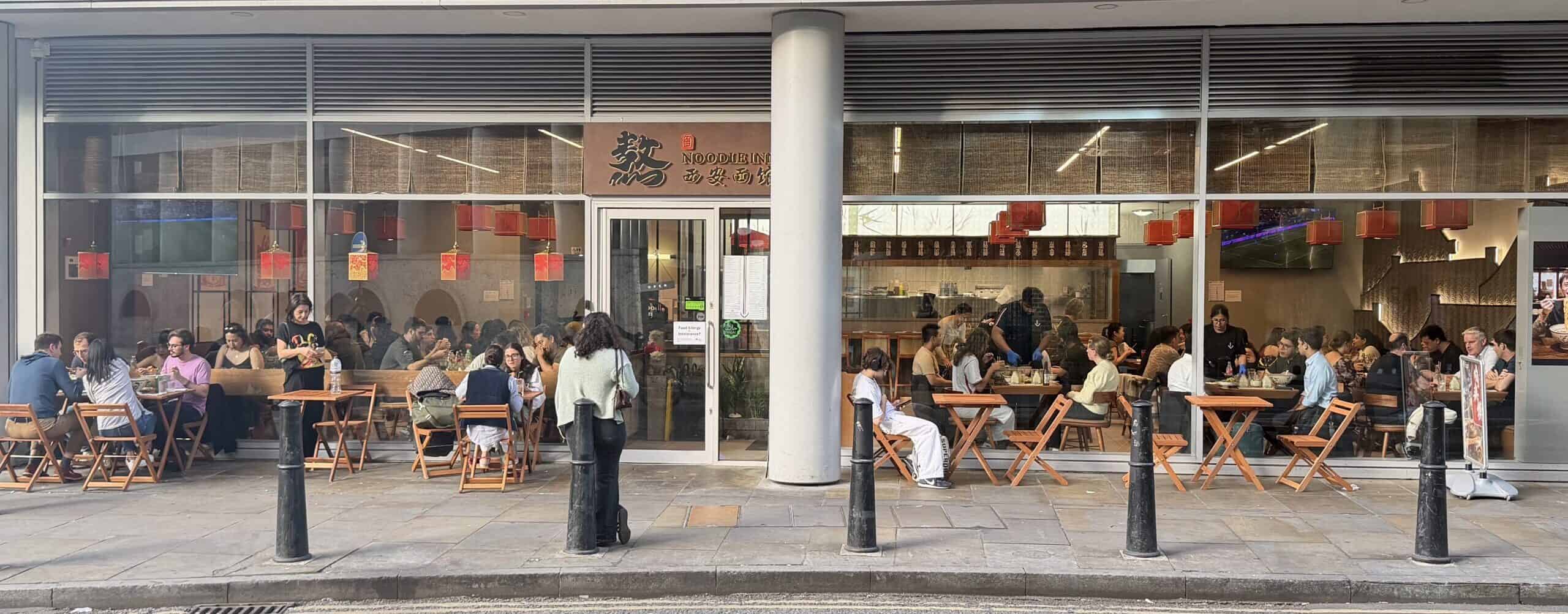 Busy Noodle Inn restaurant with outdoor seating near Liverpool Street.